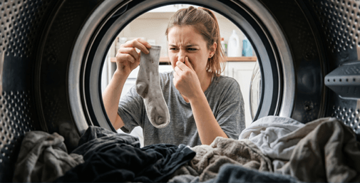 Person sorting laundry at an open washing machine
